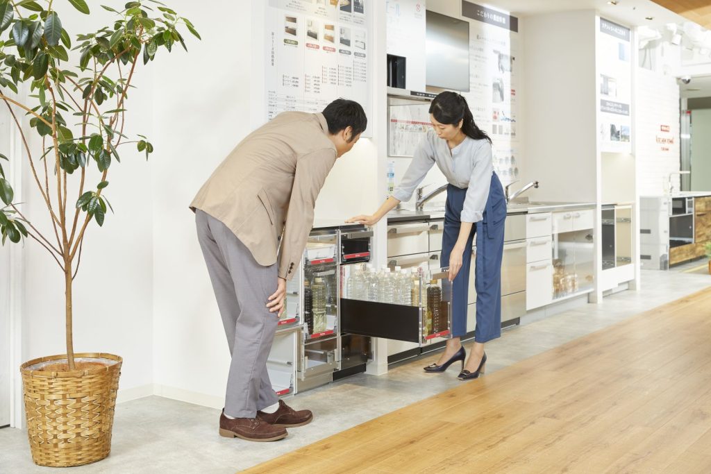 在展示廚具前拉開下櫃抽屜，確認調味料瓶的立式收納