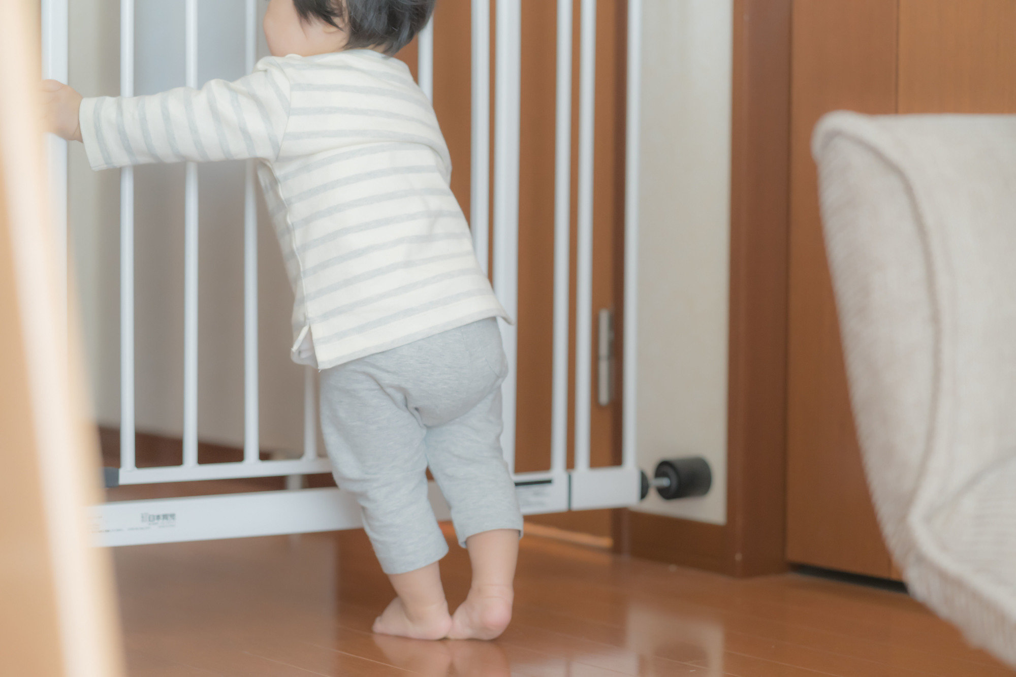 幼兒扶著兒童安全門欄的照片