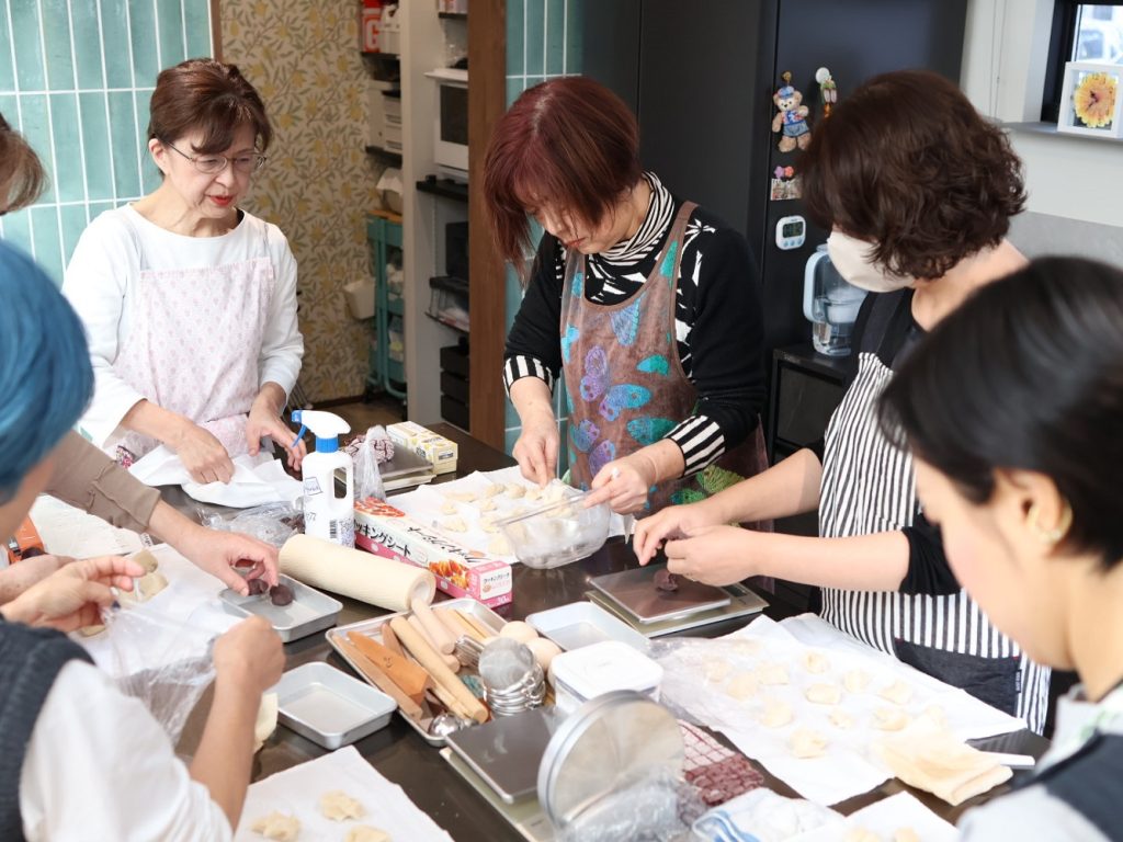 深色調空間裡，學員的笑容與作品